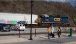 A family taking advantage of the weather and walking opportunities in downtown Lynchburg pauses to watch CSX local L206 drift by,